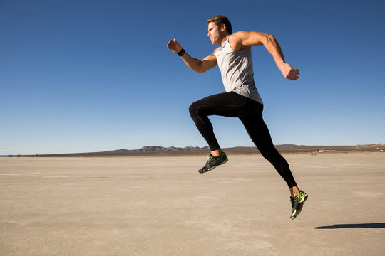 Male runner running on dry lake bed, El Mirage, California, USA