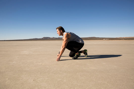 Man training, on his marks on dry lake bed, El Mirage, California, USA