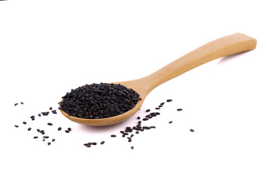Heap of black sesame on wooden spoon on white background