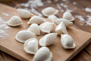 Fototapeta na wymiar Uncooked dumplings on wooden table