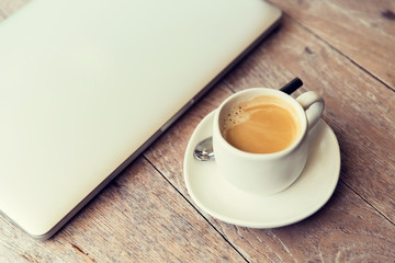close up of laptop and coffee cup on office table