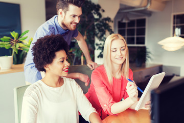 happy creative team with computer in office