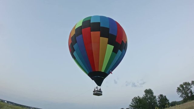 Hot air balloon takes off in meadow