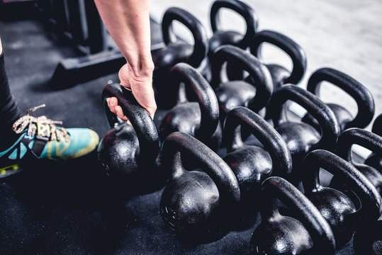 uomo solleva pesi kettelball in palestra
