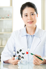 asian female scientist teacher point at molecular model explain