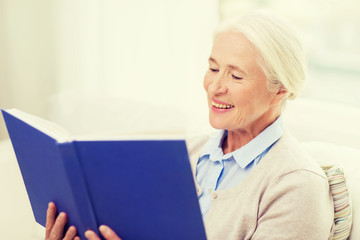 happy smiling senior woman reading book at home