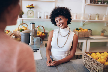 Juice bar owner talking with female customer