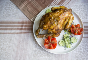 курица гриль на белой тарелке с помидорами и огурцами