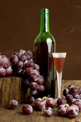 Wine glass and red grape with old steel background