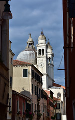 Fototapeta na wymiar Santa Maria della Salute Basilica seen from a typical Venice narrow street