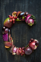 Alphabet letter made of purple vegetables and fruit on dark back