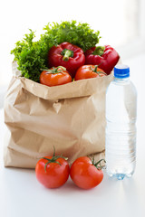 close up of paper bag with vegetables and water
