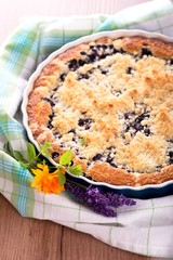 Blueberry pie on checkered towel with lavender and marigold
