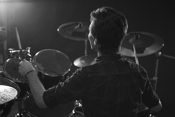 Fototapeta na wymiar Black And White Shot Of Drummer Playing Drum Kit In Studio