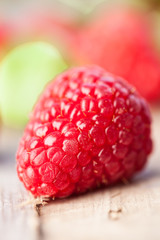 Toned photo. Color tone tuned. Ripe sweet raspberries on wooden table close-up. Selective focus.