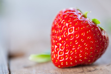 Close up of big strawberry on wood. Natural background. Selective focus.