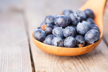 Organic blueberries in spoon. Organic blueberries in spoon on wooden. Natural background. Selective focus.