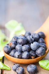 Organic blueberries in spoon. Organic blueberries in spoon on wooden. Natural background. Selective focus.