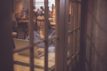 Woman with grey laptop is watched