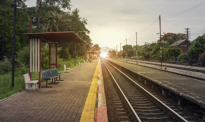 view of the length of railway with pavement at left side of railway,filtered image, light effect and flare added,selective focus,mean "Theres light at the end of the tunnel", success way
