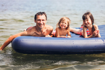 Obraz premium Family floating on mattresses.