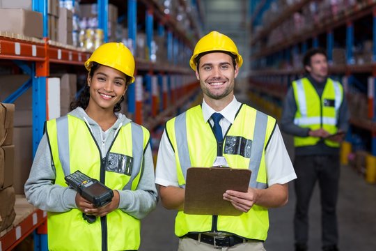 Smiling worker wearing yellow safety vest looking at camera
