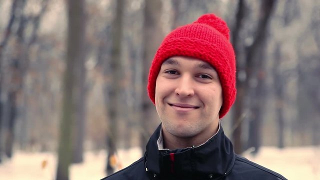 handsome guy in a red cap smiles, winter