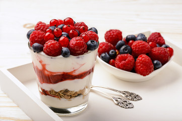 Healthy yogurt dessert with muesli, strawberry mousse, raspberries, blueberries and red currants.