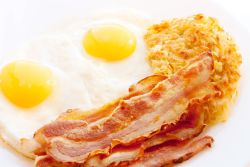 American breakfast. Bacon, Fried eggs and Hash Browns on a white background.