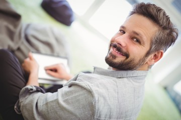 Businessman holding digital tablet in creative office