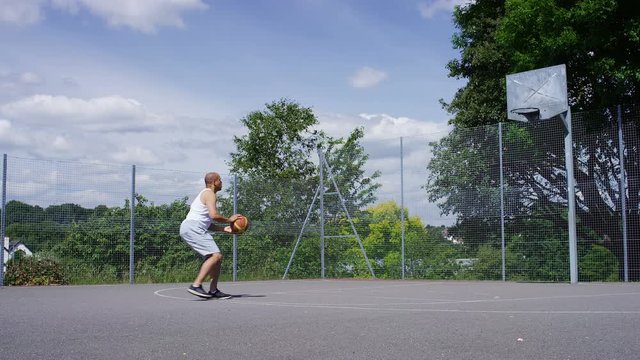 4K Casual basketball player taking a jump shot, in slow motion