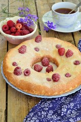 Cake with raspberries on a wooden background.