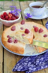 Cake with raspberries on a wooden background.