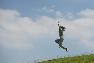 青空に向かってジャンプする女性