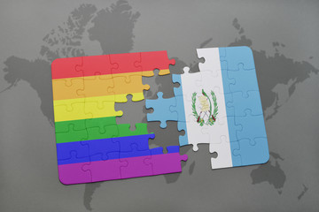 puzzle with the national flag of guatemala and gay rainbow flag on a world map background.