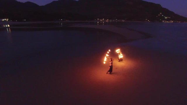 Dancing fire show on the beach at sunset
