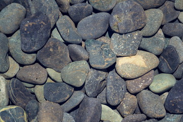 Grey stone pebbles under water lake bed background