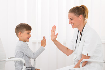 Doctor Giving High Five To Boy