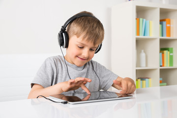 Boy Listening Music On Digital Tablet