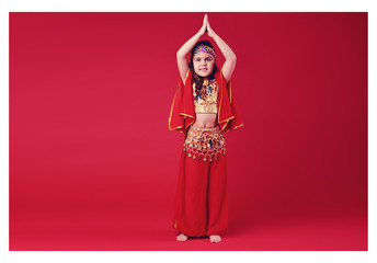 Close up shot of a belly dancer wearing a blue, gold and green costume shaking her hips. Isolated on white. Clipping path included so image can be easily transferred to a different colored background.