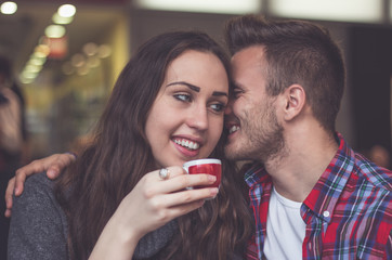 Portrait of a young beautiful couple flirting in cafe