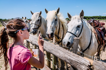 Obraz premium Fillette et chevaux blancs camarguais
