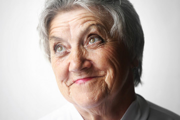 Obraz premium Looking old woman portrait on a gray background