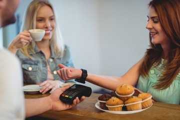 Happy customer with smart watch paying at cafe