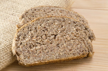 Home baked brown bread slices on wooden table