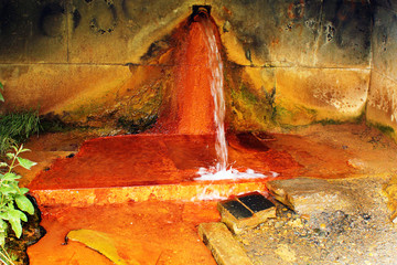 Narzan mineral water spring in Caucasus mountains, Georgia. High concentration of iron gives it rusty orange color.