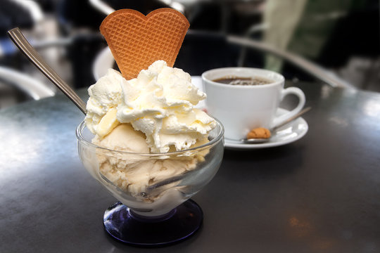 sundae with ice cream, whipped cream and biscuit and a cup of coffee