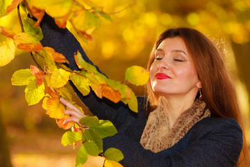 Naklejka na ściany i meble Attractive girl among trees and leaves