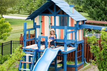 Little girl in chair on outdoor playset