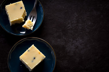 Passionfruit Slice on Plates from Above Dark Background with Copy Space